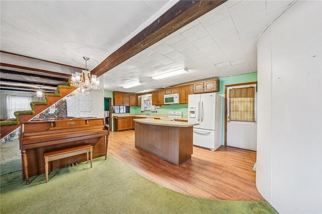 kitchen with a center island, light wood-type flooring, light countertops, brown cabinets, and white appliances