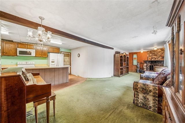 living area with a stone fireplace, a notable chandelier, light colored carpet, and a textured ceiling