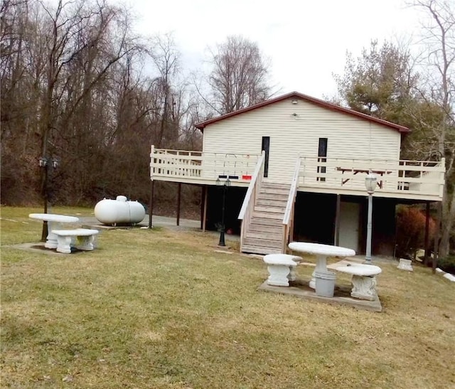 back of property with stairway, a yard, and a deck