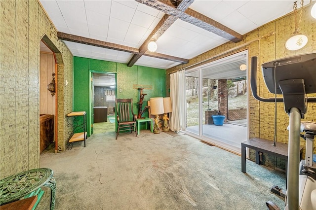 living area with beamed ceiling and carpet floors