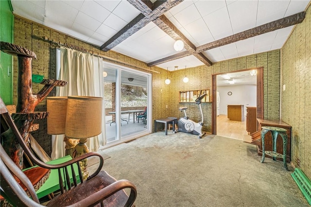 living area featuring beamed ceiling and carpet