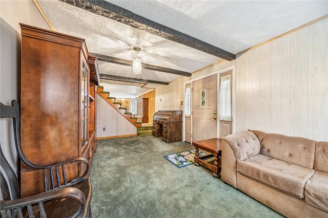 living room featuring stairway, beamed ceiling, wood walls, carpet floors, and a textured ceiling