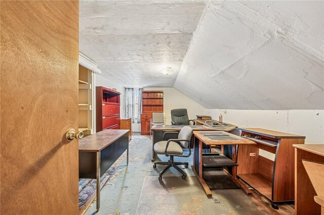 office area featuring lofted ceiling and concrete flooring