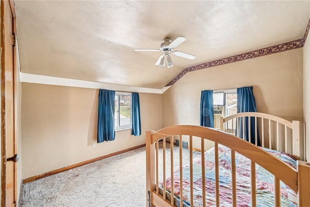 carpeted bedroom with a ceiling fan, baseboards, and vaulted ceiling