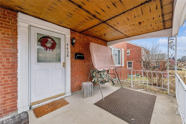 property entrance with brick siding and a balcony