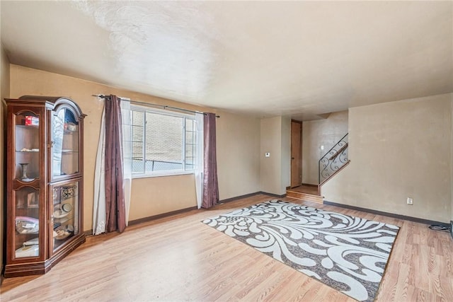 interior space with stairs, light wood-style floors, and baseboards