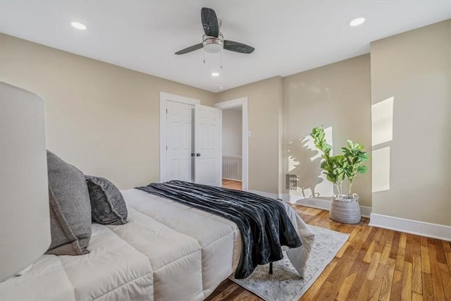 bedroom with a ceiling fan, recessed lighting, wood finished floors, and baseboards