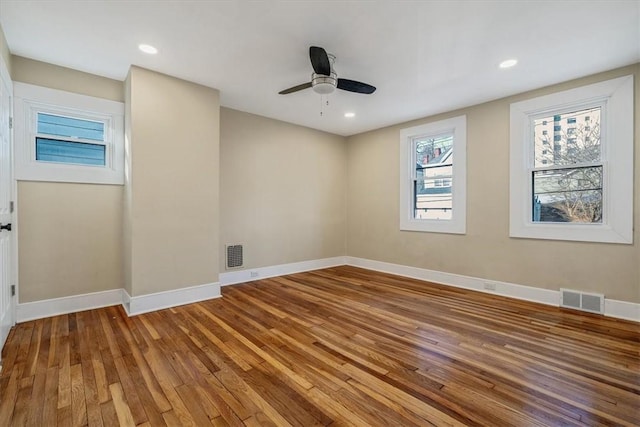 empty room featuring recessed lighting, visible vents, baseboards, and hardwood / wood-style flooring