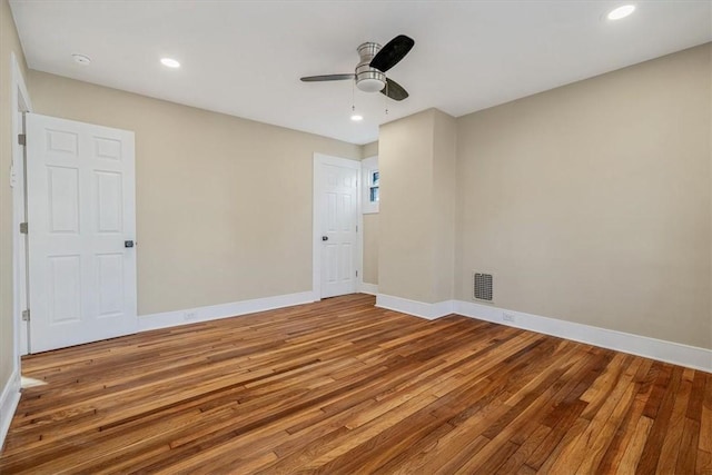 empty room with recessed lighting, baseboards, visible vents, and wood-type flooring