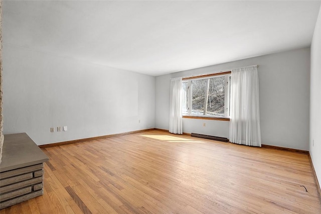 spare room featuring baseboards and wood finished floors