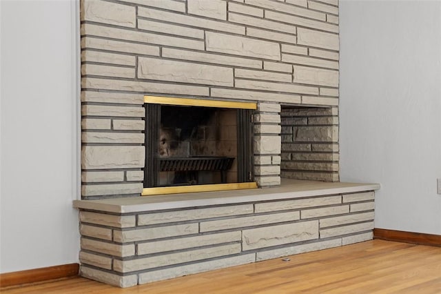 interior details featuring a fireplace, baseboards, and wood finished floors