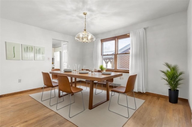 dining room featuring an inviting chandelier, light wood-style flooring, and baseboards