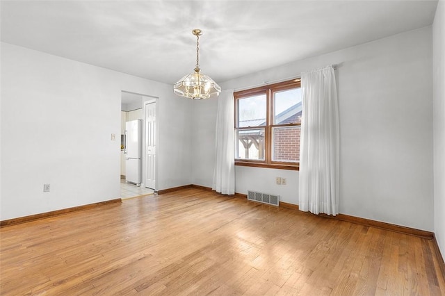 empty room with baseboards, visible vents, a chandelier, and light wood-type flooring