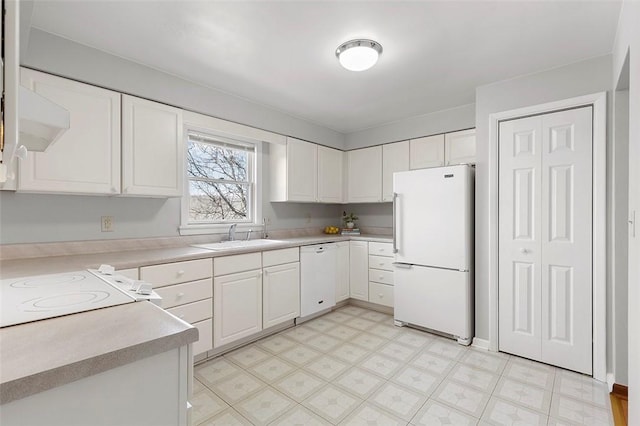 kitchen featuring light floors, white appliances, white cabinetry, and a sink