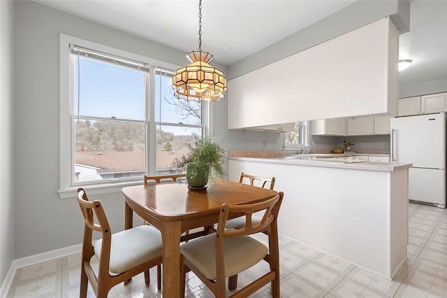 dining room featuring light floors and baseboards