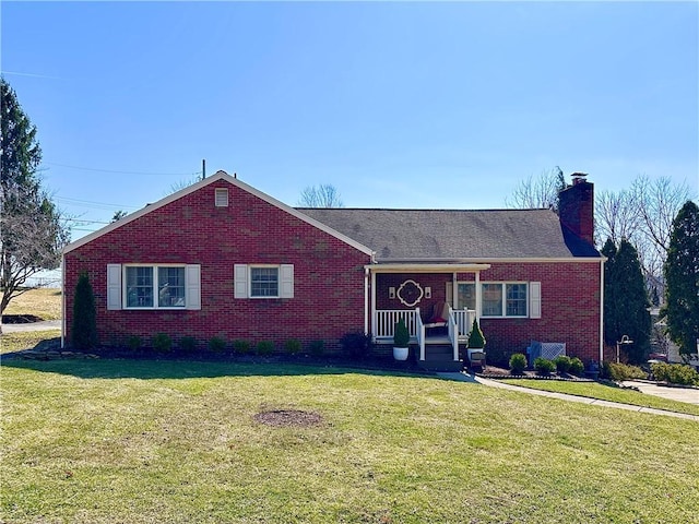 ranch-style home with brick siding, a chimney, and a front yard