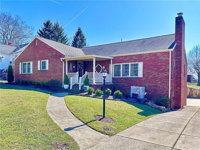 single story home with a chimney, brick siding, a porch, and a front lawn