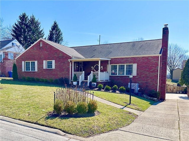 ranch-style home featuring brick siding, covered porch, and a front lawn