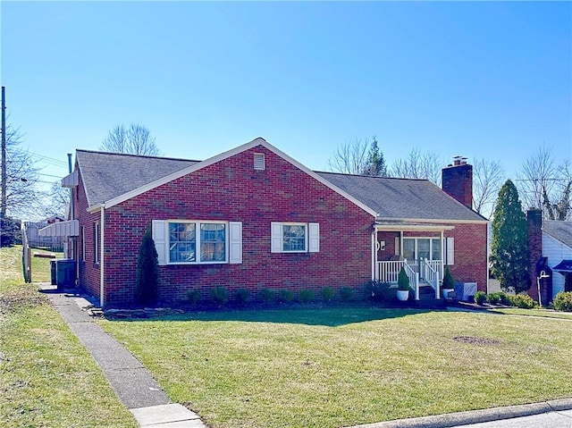 ranch-style home with a front lawn, brick siding, and a chimney