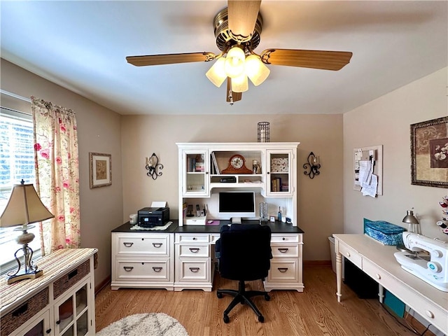 office with light wood finished floors and ceiling fan