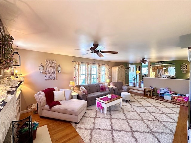 living room featuring a ceiling fan and wood finished floors