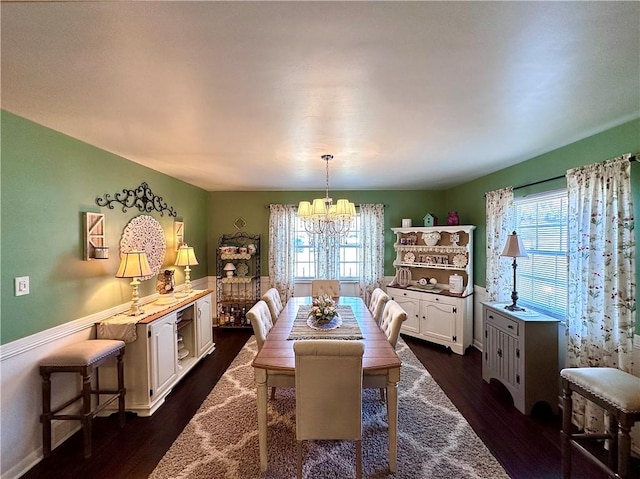 dining room featuring dark wood finished floors, plenty of natural light, and an inviting chandelier