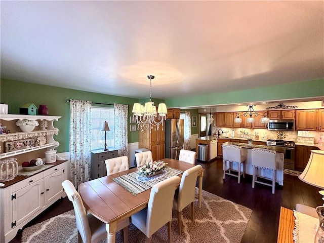 dining room featuring a chandelier and dark wood-style flooring