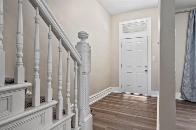 foyer entrance with stairway, wood finished floors, and baseboards