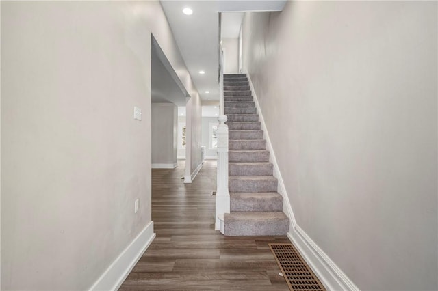 stairway with recessed lighting, wood finished floors, visible vents, and baseboards