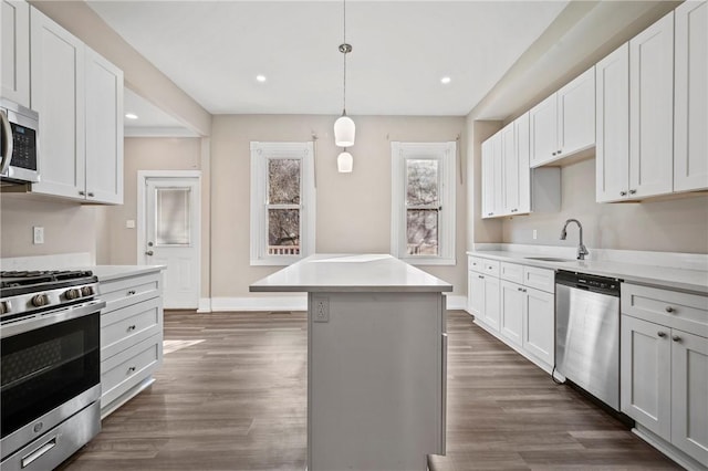 kitchen featuring light countertops, dark wood-style flooring, appliances with stainless steel finishes, and a kitchen island