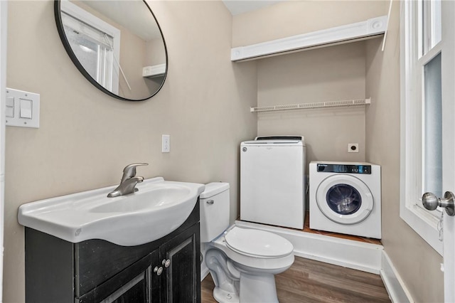 bathroom with vanity, wood finished floors, baseboards, toilet, and washer and clothes dryer