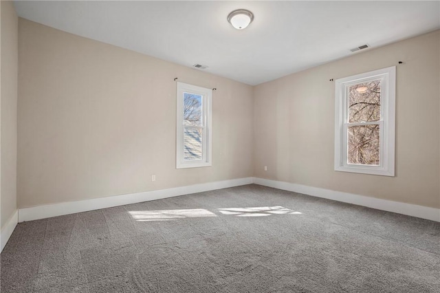 empty room featuring visible vents, baseboards, and carpet