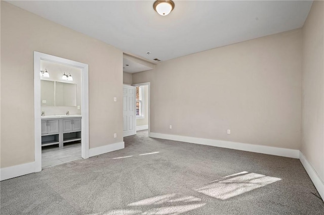 unfurnished bedroom with visible vents, carpet, baseboards, and ensuite bathroom