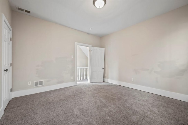 carpeted spare room featuring baseboards and visible vents