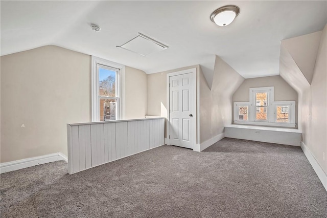 additional living space with a healthy amount of sunlight, baseboards, carpet, and vaulted ceiling