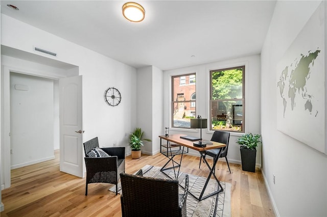 office area featuring visible vents, light wood-style flooring, and baseboards