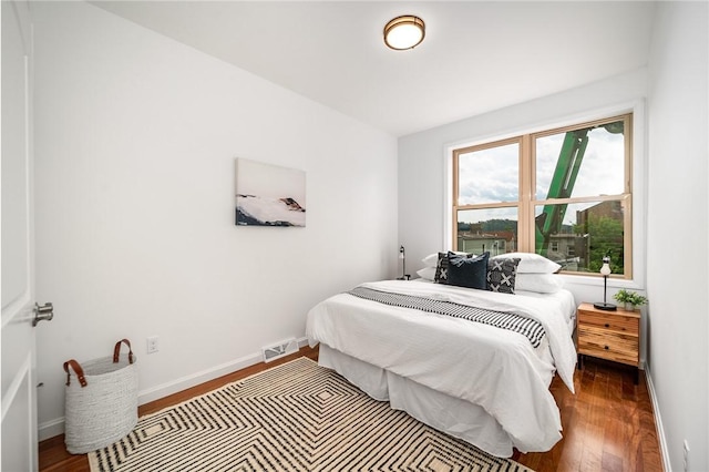 bedroom featuring visible vents, baseboards, and wood finished floors