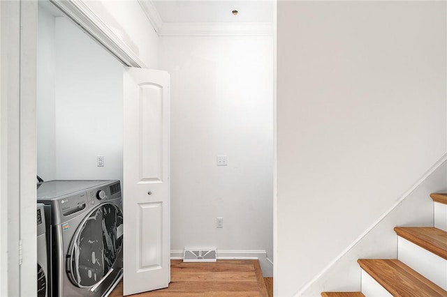 laundry room featuring baseboards, visible vents, laundry area, ornamental molding, and light wood-type flooring