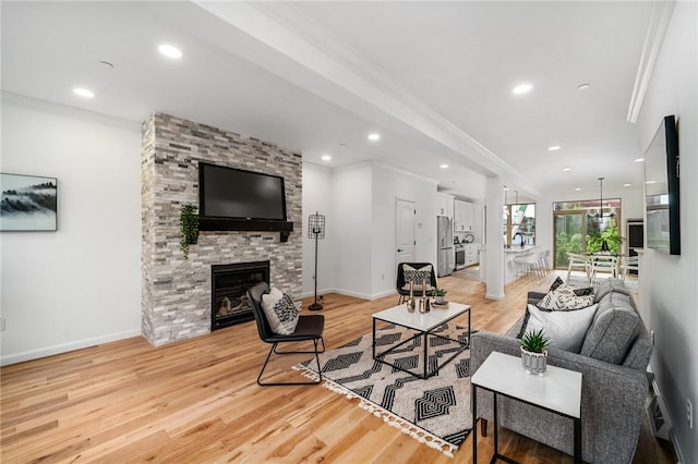 living room featuring crown molding, recessed lighting, light wood-type flooring, and baseboards