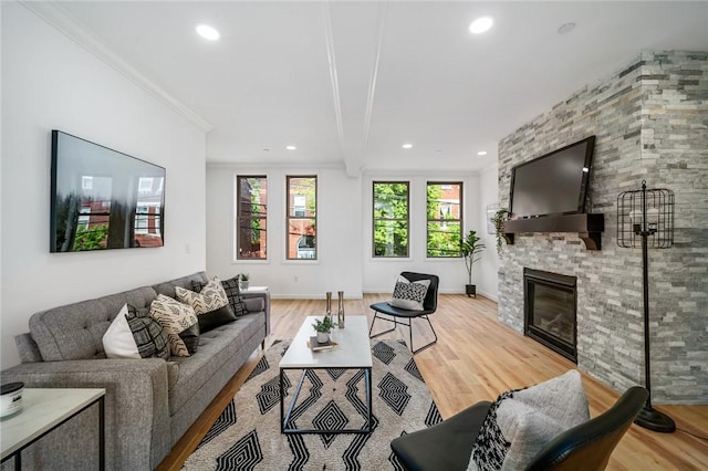 living area featuring a large fireplace, recessed lighting, wood finished floors, and ornamental molding