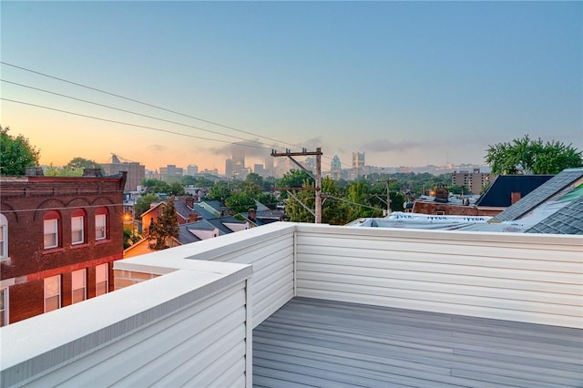 deck at dusk featuring a view of city