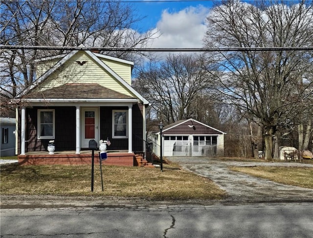 view of front of property featuring an outbuilding, a porch, and a detached garage