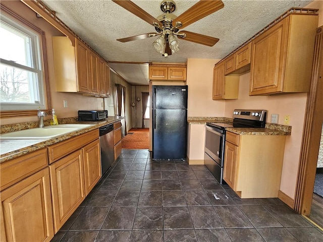 kitchen with a sink, a textured ceiling, a ceiling fan, and stainless steel appliances