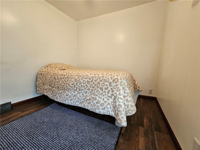 bedroom featuring baseboards and wood finished floors