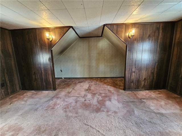 bonus room featuring wood walls and carpet