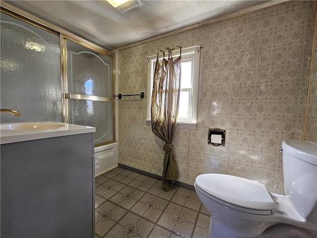 bathroom featuring vanity, toilet, visible vents, and bath / shower combo with glass door