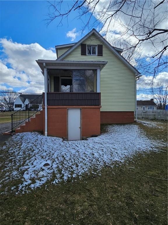 rear view of property with stairway and a sunroom