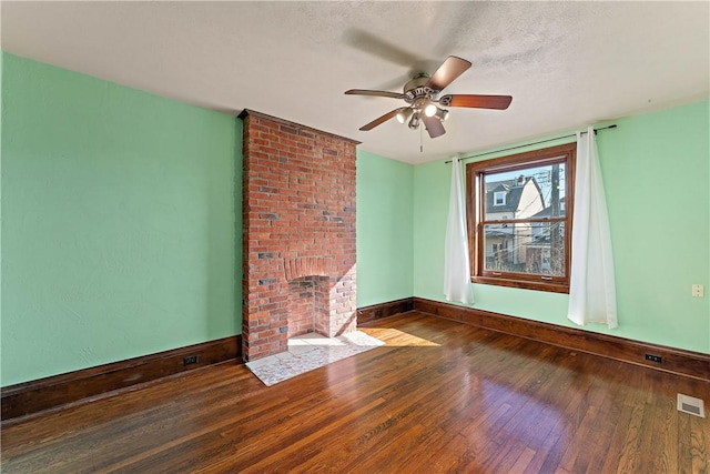 unfurnished living room featuring visible vents, baseboards, a fireplace, hardwood / wood-style flooring, and a textured ceiling