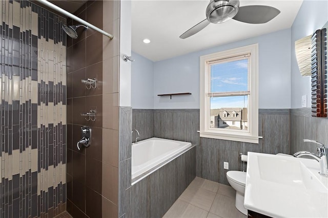 full bathroom with a tile shower, wainscoting, a bath, and a sink