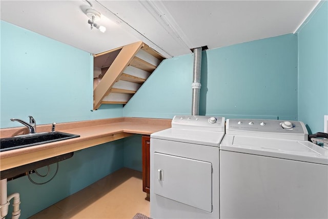 laundry area with laundry area, washing machine and dryer, and a sink